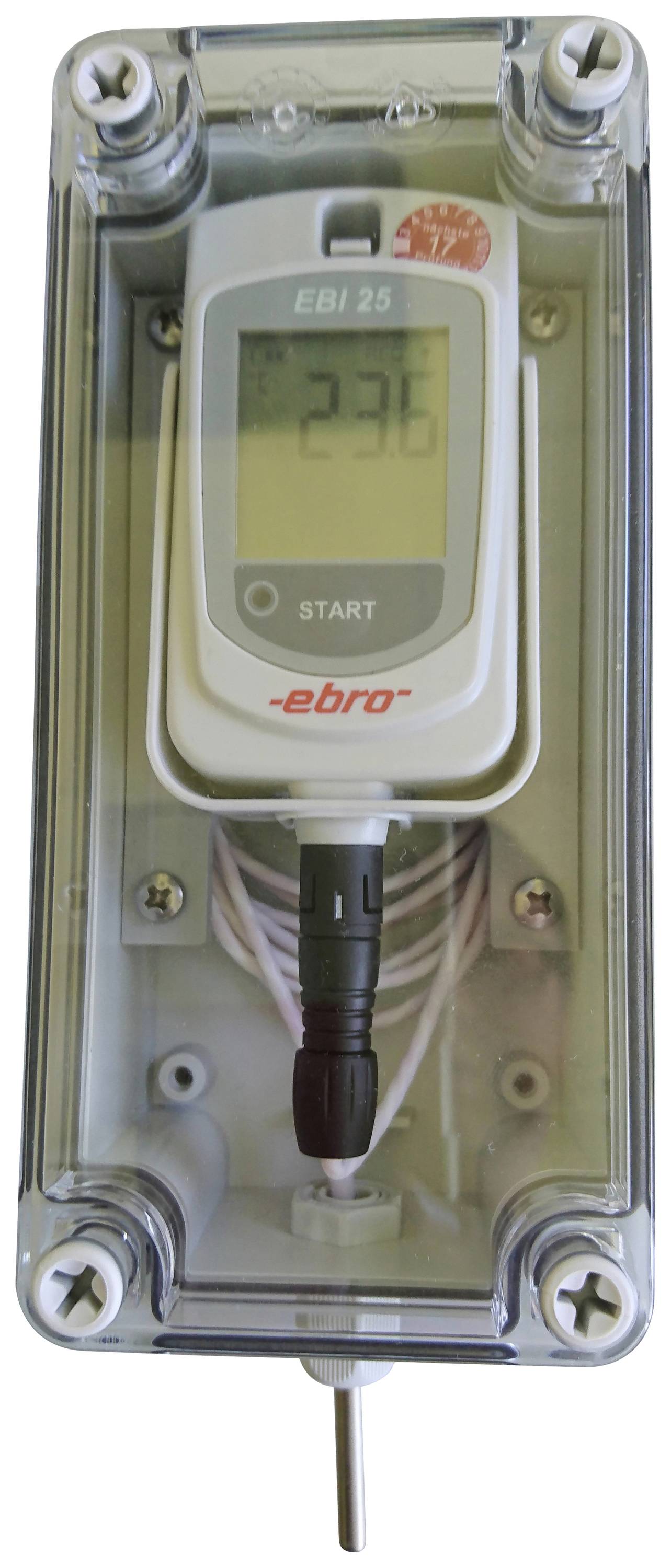 Ein digitales Thermometer in einem transparenten Gehäuse zeigt '23.6' Grad Celsius an. Es hat eine Starttaste und ist mit einem Kabel verbunden.