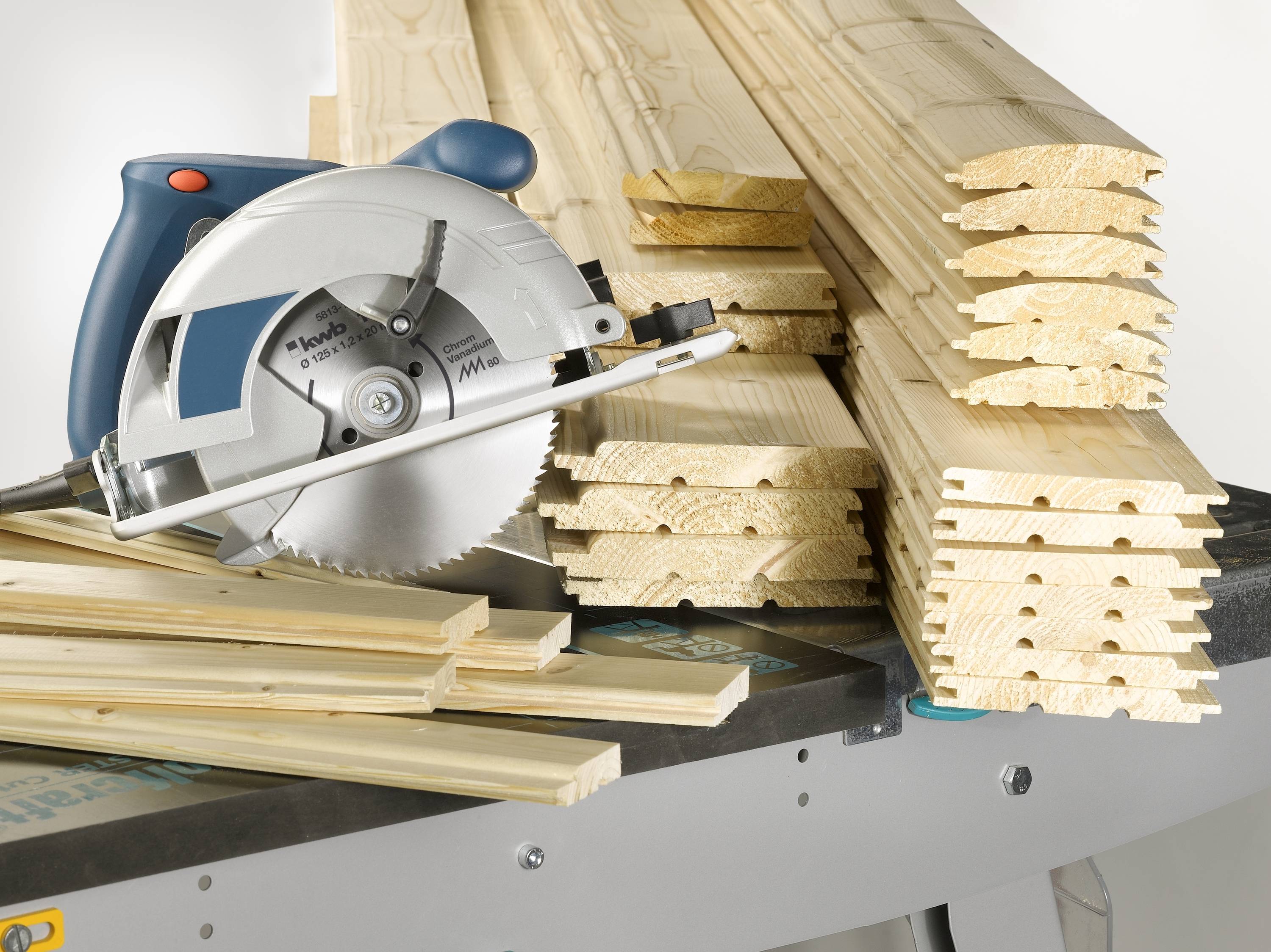 Stapel von Holzlatten auf einer Werkbank neben einer Handkreissäge.