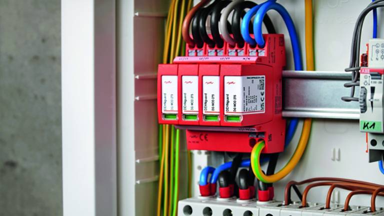 Elektrischer Schaltschrank mit mehreren roten Schutzschaltern und farbigen Kabeln. Sorgt für elektrische Sicherheit und Verteilung.