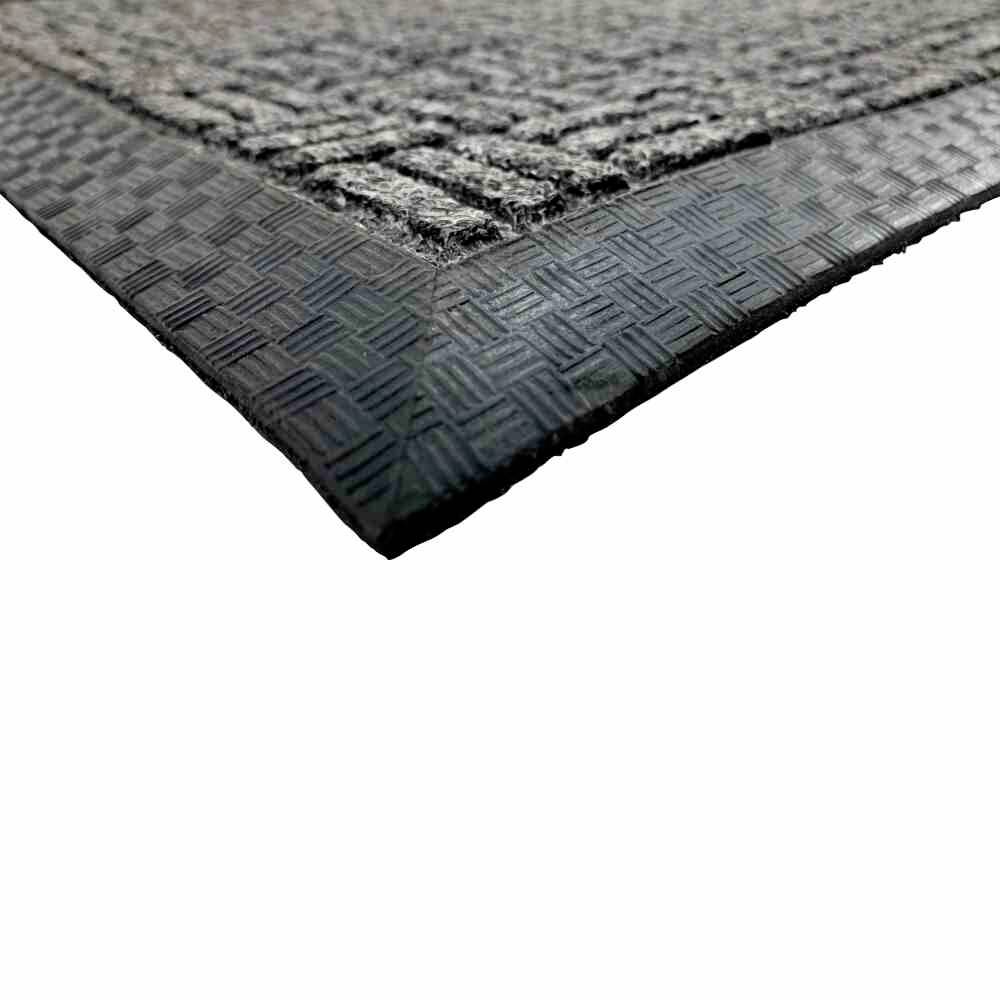 Eine Fußmatte mit schwarz-grauer Textur und erhöhter Gummirandkante. Sie wirkt rutschfest und robust, für den Eingangsbereich geeignet.