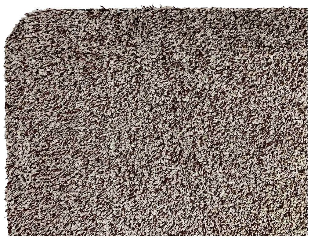 Ein Rechteck aus dichtem, strukturiertem Stoff in beige- und brauntönen, möglicherweise ein Teppich oder Polstermaterial.