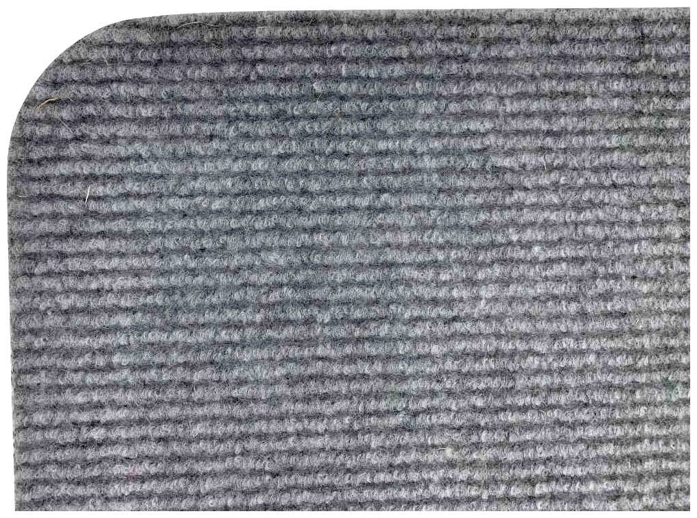 Grauer Teppichboden mit feuchten Flecken in der oberen linken Ecke. Strukturierte Faseroberfläche, zeigt leichte Verfärbungen.