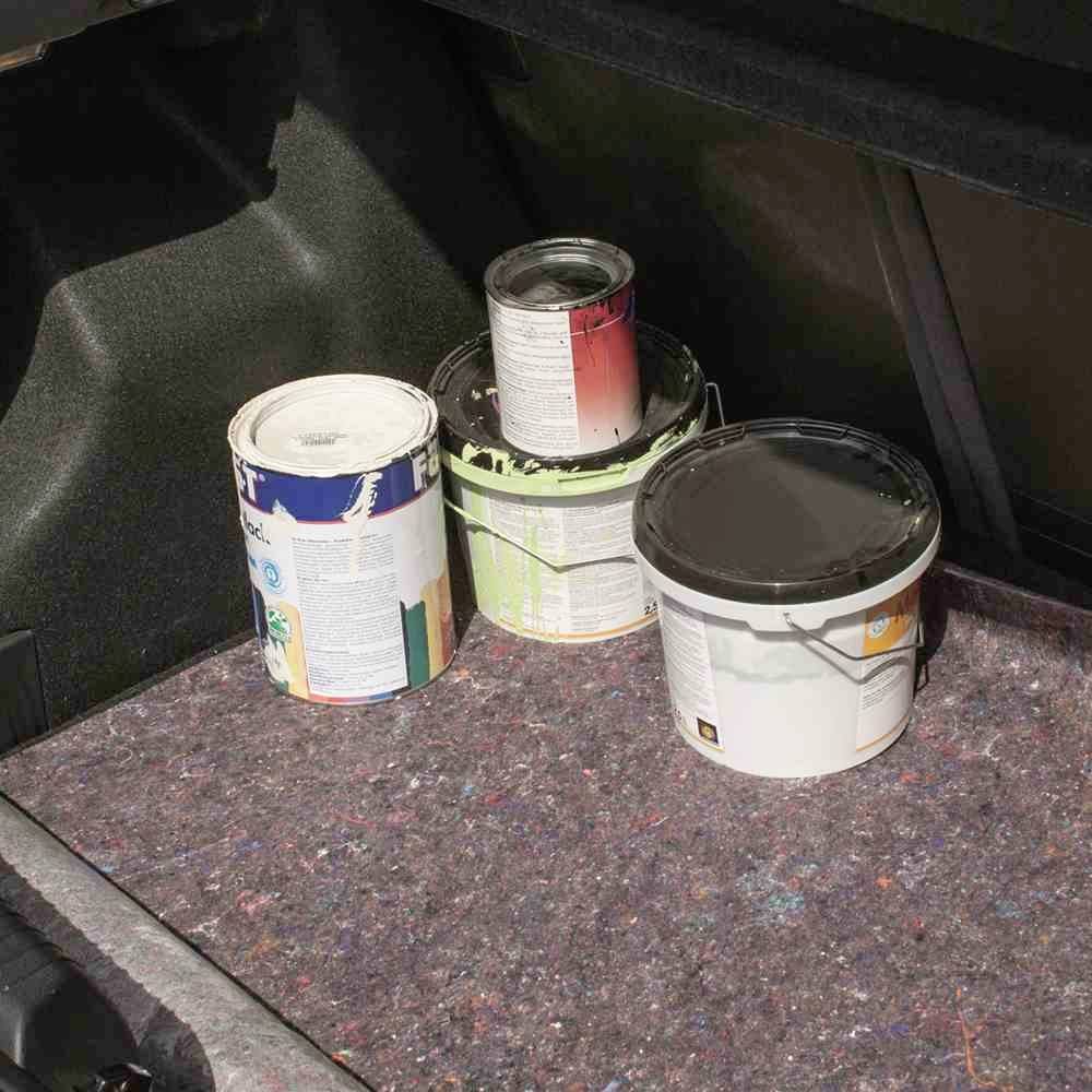 Mehrere Farbdosen stehen im Kofferraum eines Autos, auf einer Abdeckung platziert. Die Dosen haben verschiedene Farben.