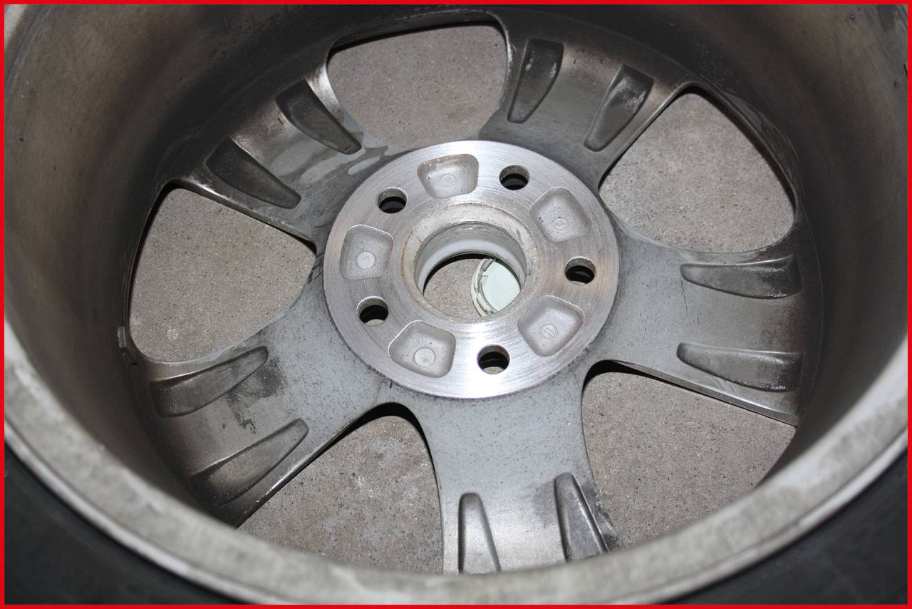 Eine Aluminiumfelge mit mehreren Speichen, gezeigt von innen. Die Oberfläche ist abgenutzt und zeigt leichte Verschmutzungen.