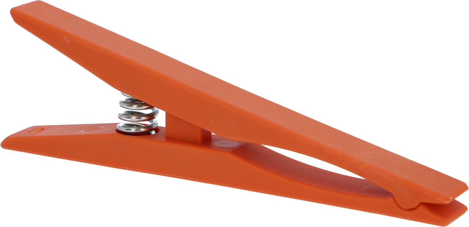Eine orangefarbene Wäscheklammer aus Kunststoff mit Metallfeder, aufrecht auf einer Seite liegend.