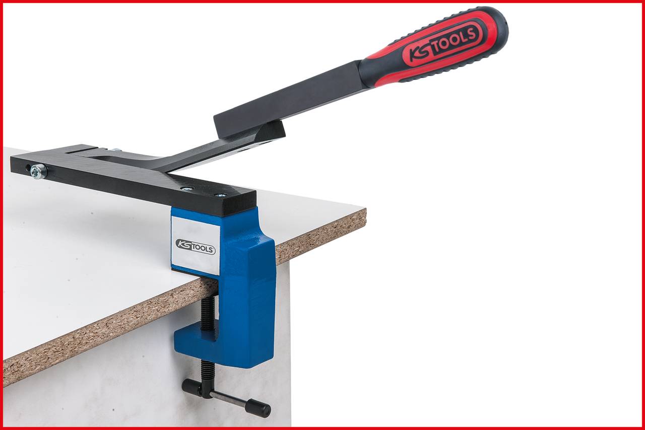 Werkbankspanner von KS Tools fixiert Holzplatte am Rand eines Tisches. Rote und schwarze Griffe, blaue Klammer.