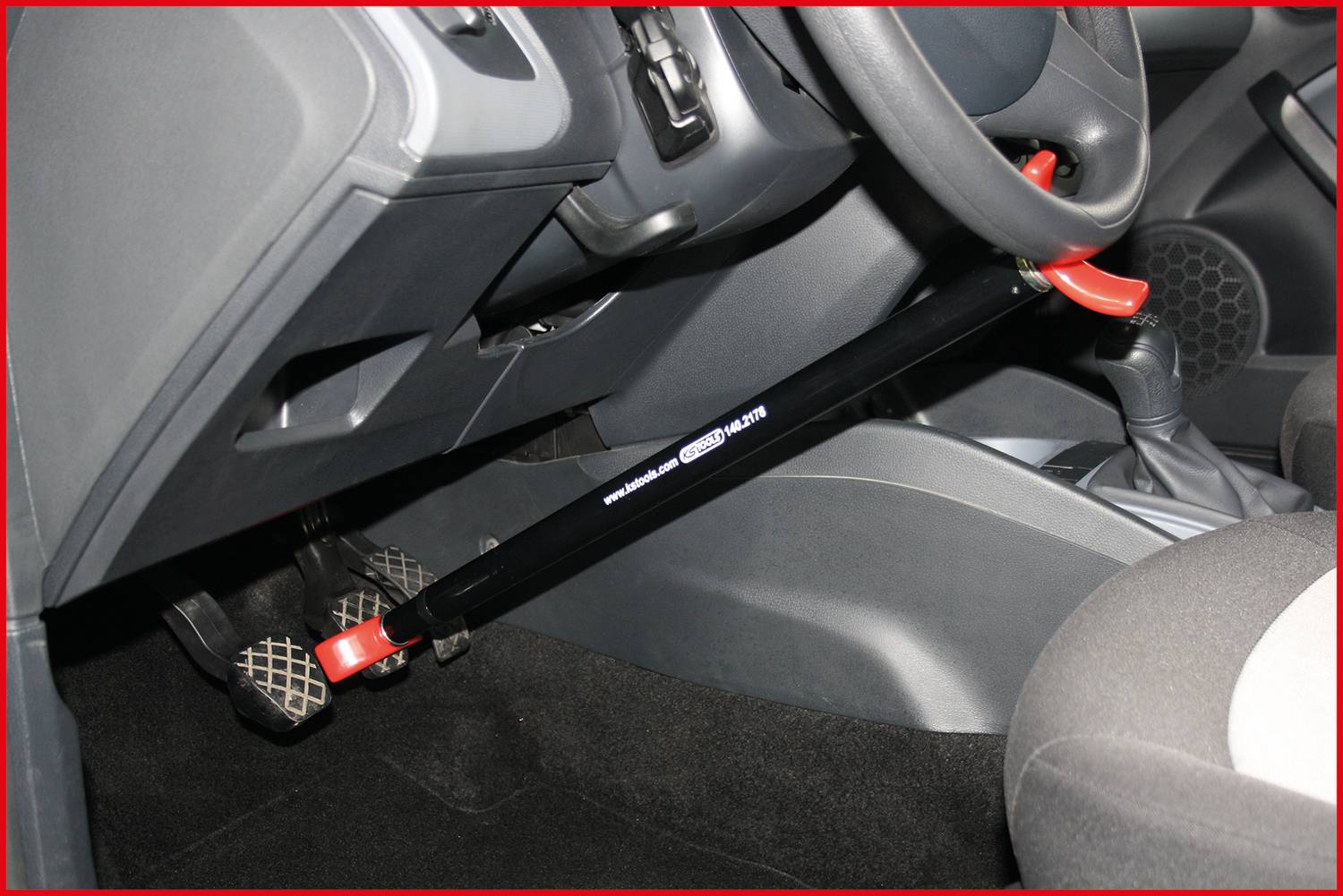 Lenkrad-Diebstahlsicherung im Auto, befestigt an Pedalen. Schützt gegen unbefugtes Fahren durch Blockierung von Lenkrad und Pedalen.