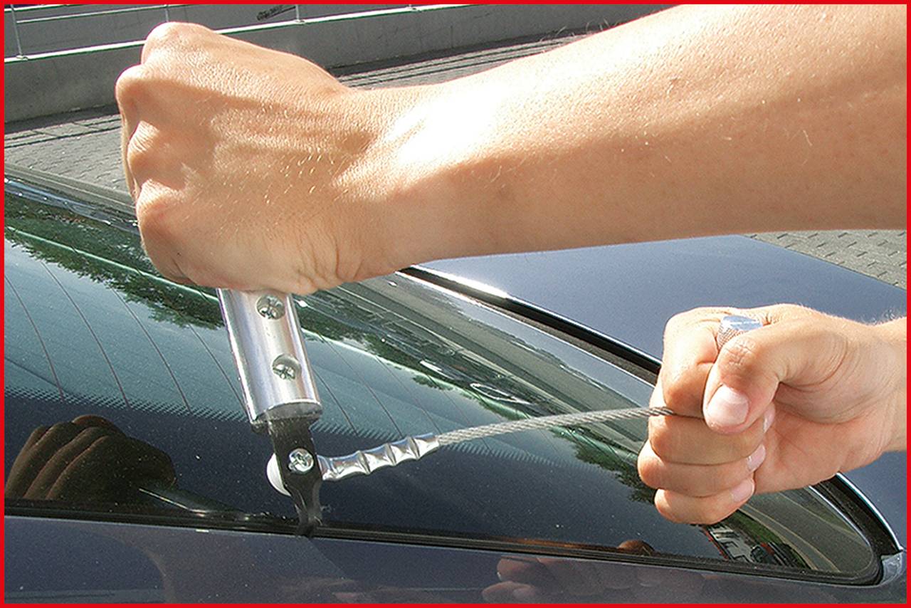 Demonstration der Anwendung eines Sauggriffwerkzeugs auf einer Autoscheibe, um das Entfernen oder Anheben des Glases zu erleichtern.