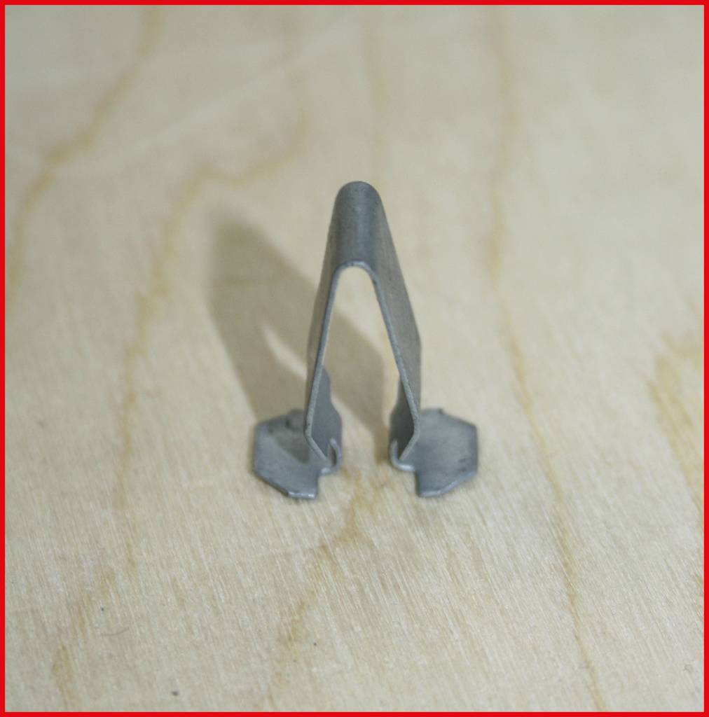 Metallclip auf Holzhintergrund, Seitenansicht.