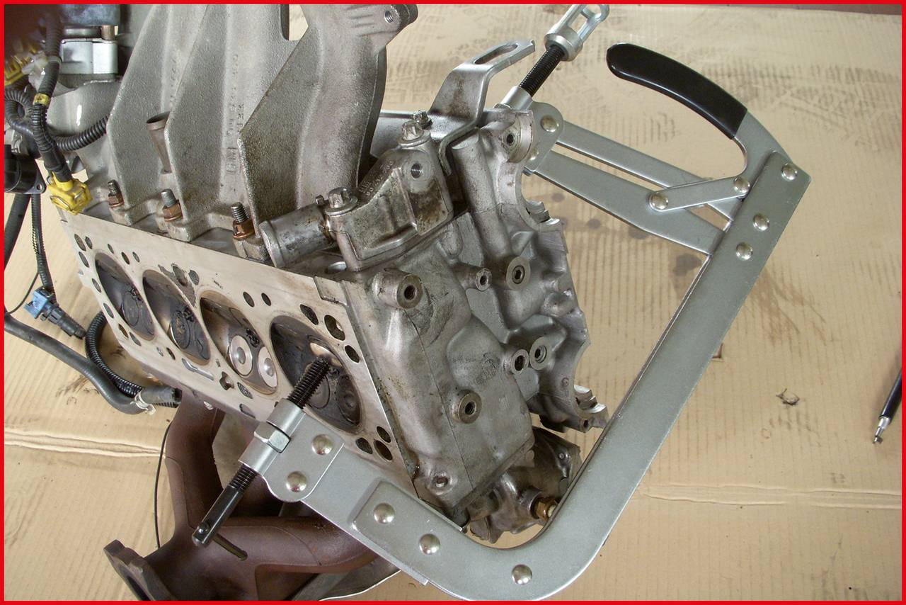 Motormontage mit Befestigungsrahmen: Ein unvollständiger Motor liegt auf einem Arbeitstisch, stabilisiert durch einen Metallrahmen.