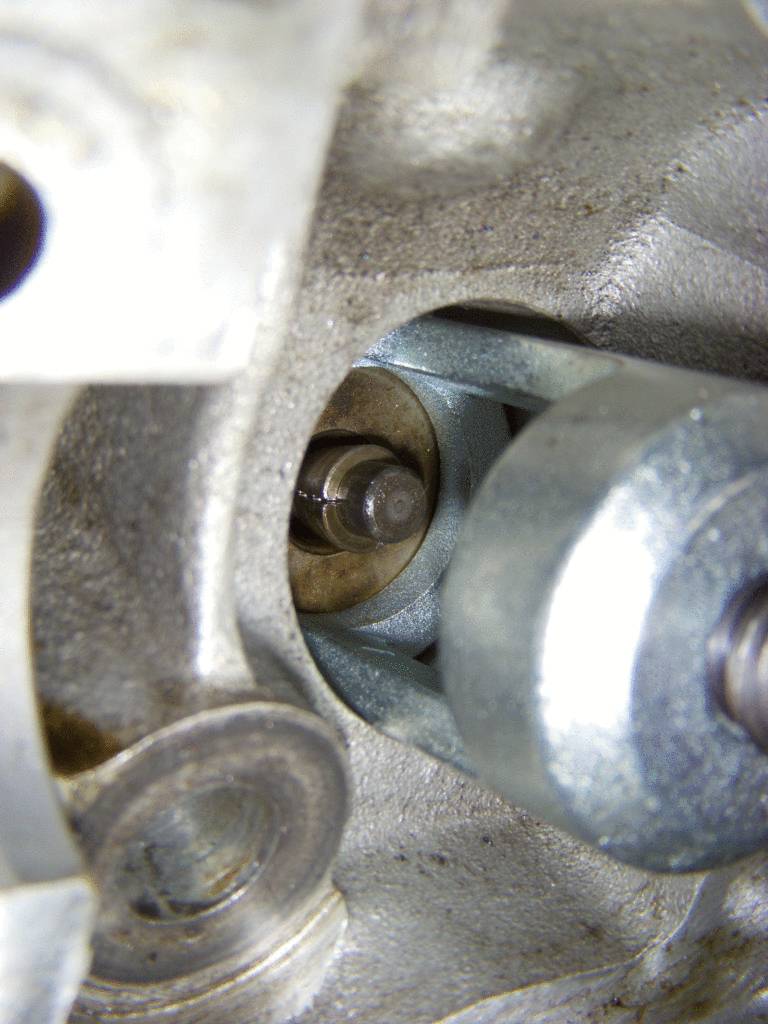Nahaufnahme eines Nockenwellenlagers in einem Motor. Sichtbar sind der schmierende Bolzen und die Lagerung, wichtig für die Motorfunktion.