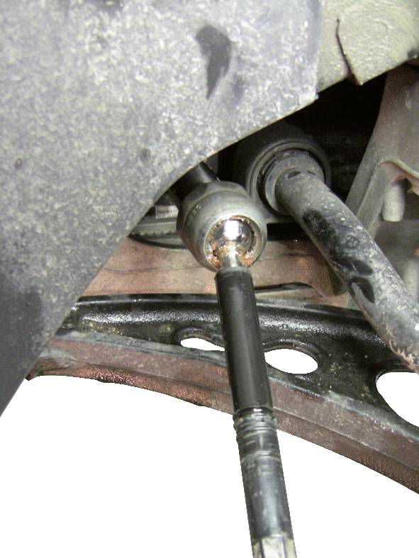 Autoteil in Nahaufnahme, zeigt ein befestigtes Lenkgestänge mit angrenzenden Teilen einer Radaufhängung.