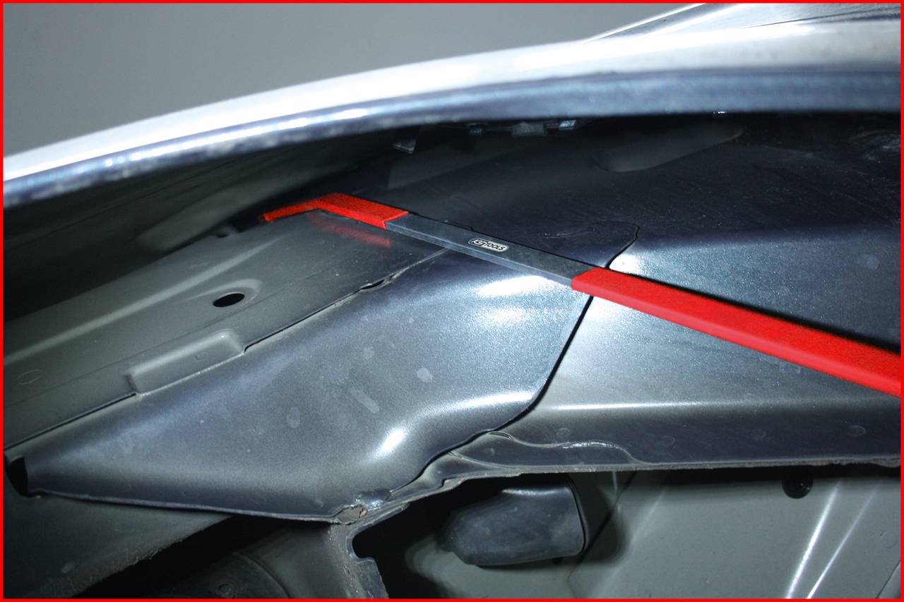 Metallstrebe unter der Motorhaube eines Autos, die ein Teil befestigt.