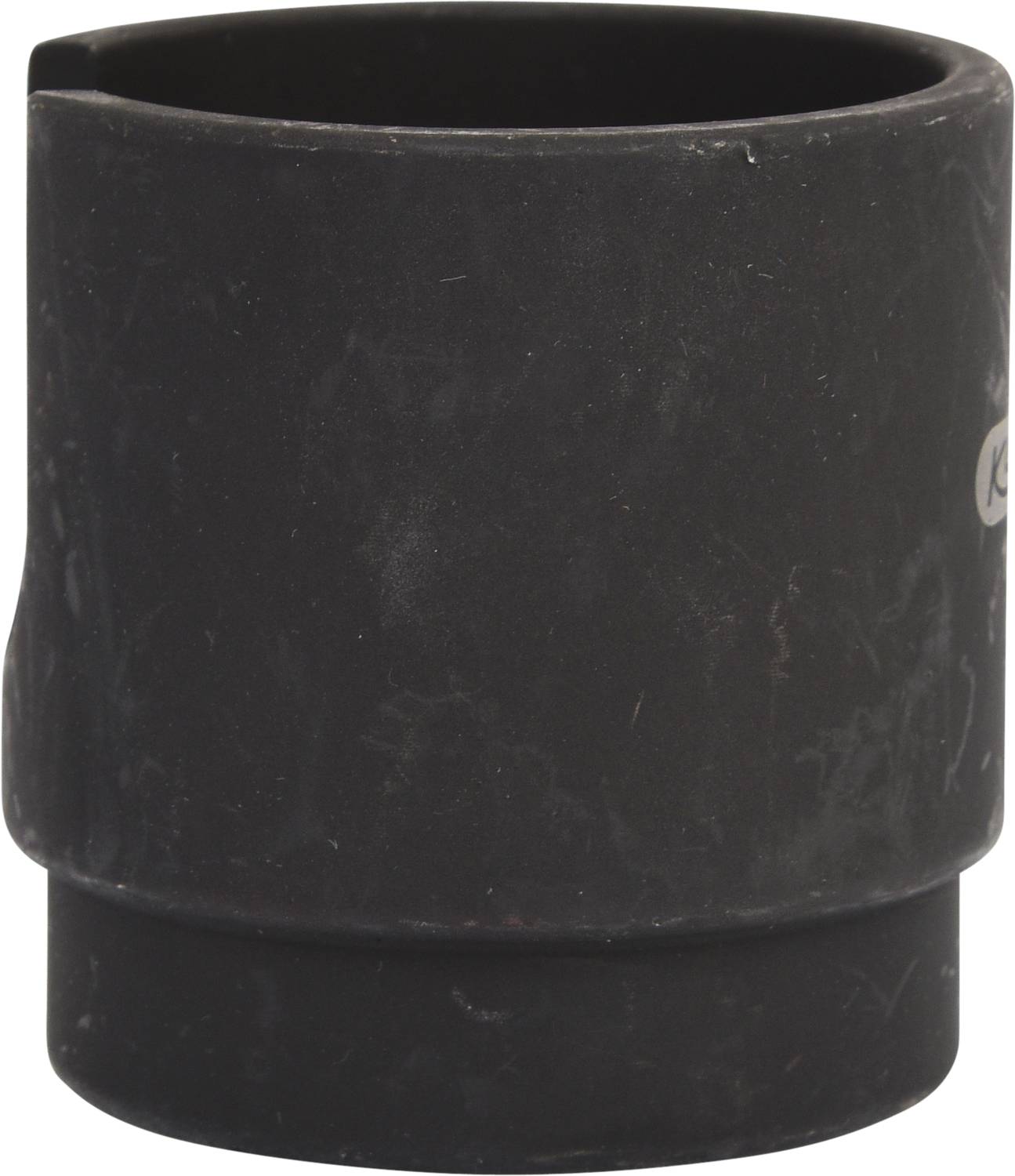 Ein schwarzes, zylinderförmiges Objekt mit abgeschrägten Rändern. Es scheint aus Kunststoff gefertigt zu sein.