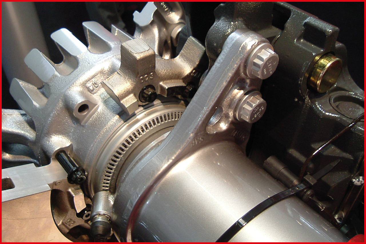 Detailansicht eines Metallmaschinenteils mit Verzahnungen und Bolzen, wahrscheinlich ein Teil eines Motors oder Turbinenmechanismus.