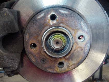 Nahaufnahme einer Bremsscheibe mit sichtbarer Nabe und Schraubenlöchern, Teil eines Fahrzeugbremssystems.