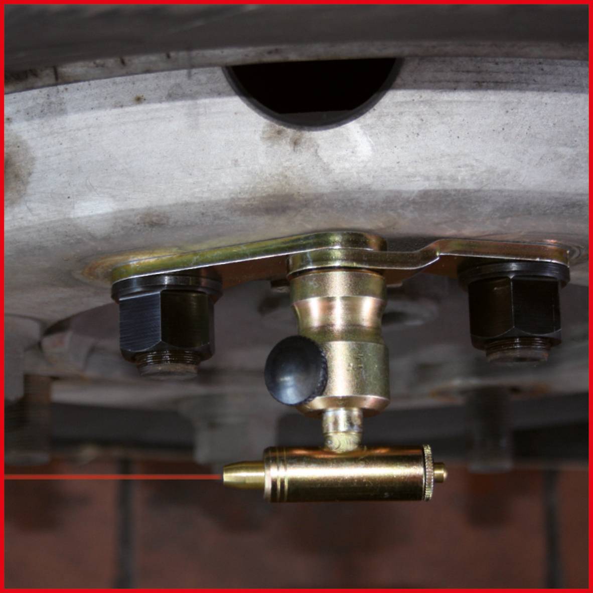 Nahaufnahme eines Autoreifens mit installiertem TPMS-Sensor (Reifendruckkontrollsystem), der an der Felge befestigt ist.