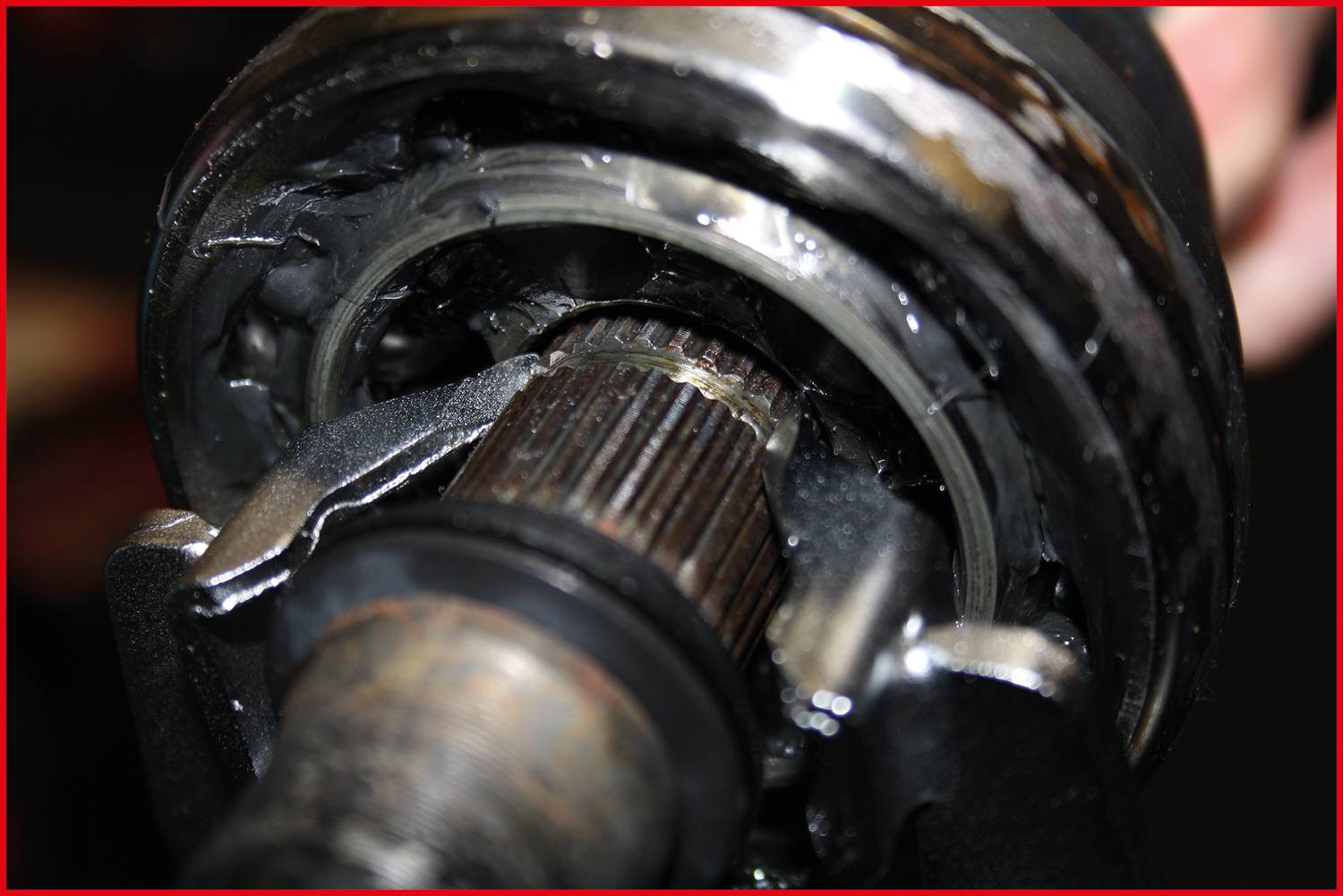 Nahaufnahme eines mechanischen Bauteils mit einem Zahnrad und Schmiermitteln. Das Bild zeigt Details der Verzahnung und Metallstruktur.