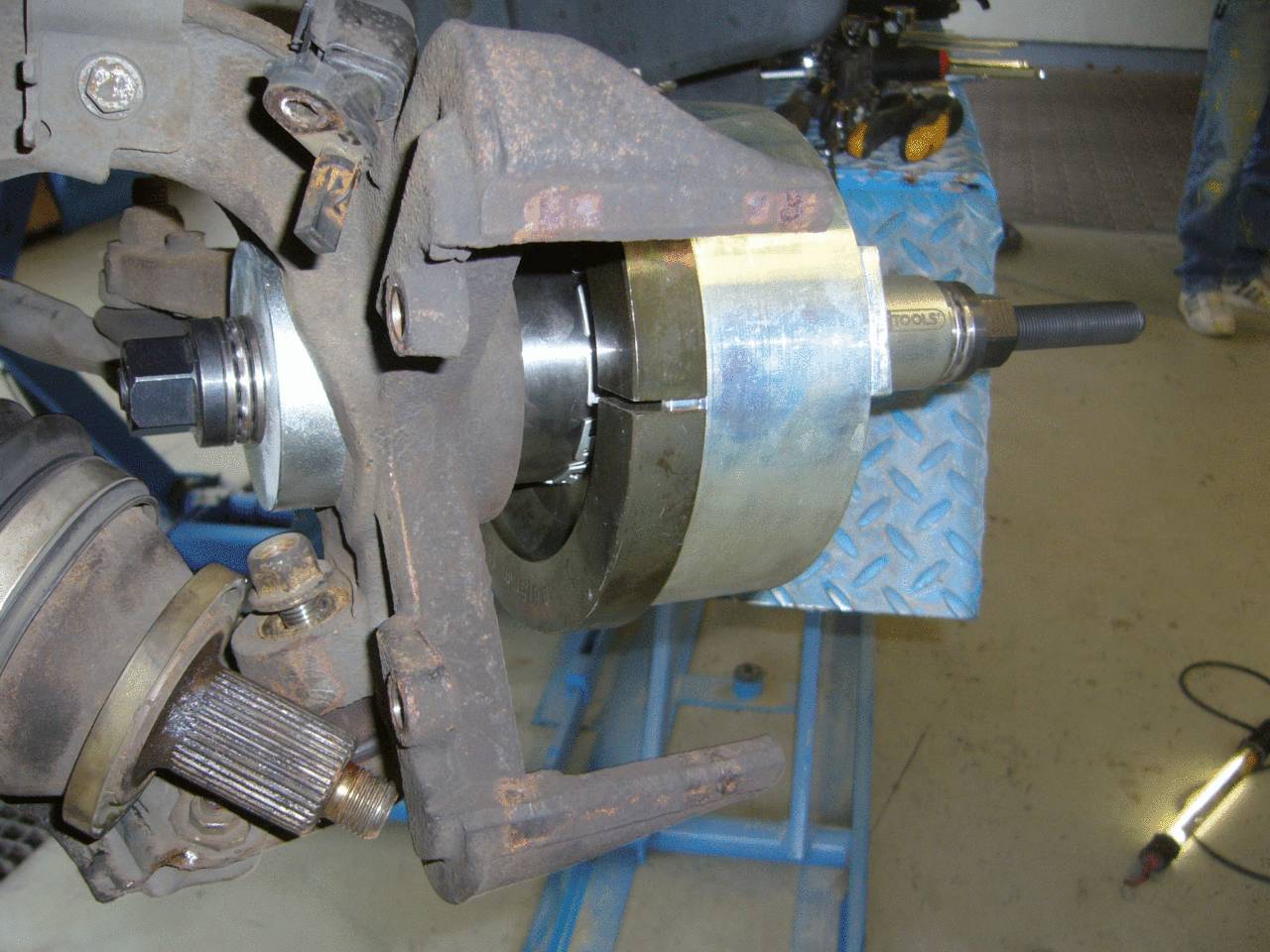 Nahaufnahme eines Werkzeugs, das bei der Reparatur oder Wartung von Autoteilen verwendet wird, wahrscheinlich im Bereich der Achsen oder Lager.