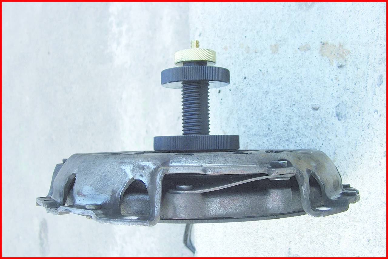 Mechanisches Gerät mit einer Schraube, die in eine kreisförmige Metallplatte eingesetzt ist. Es scheint sich um ein Werkzeugteil zu handeln.