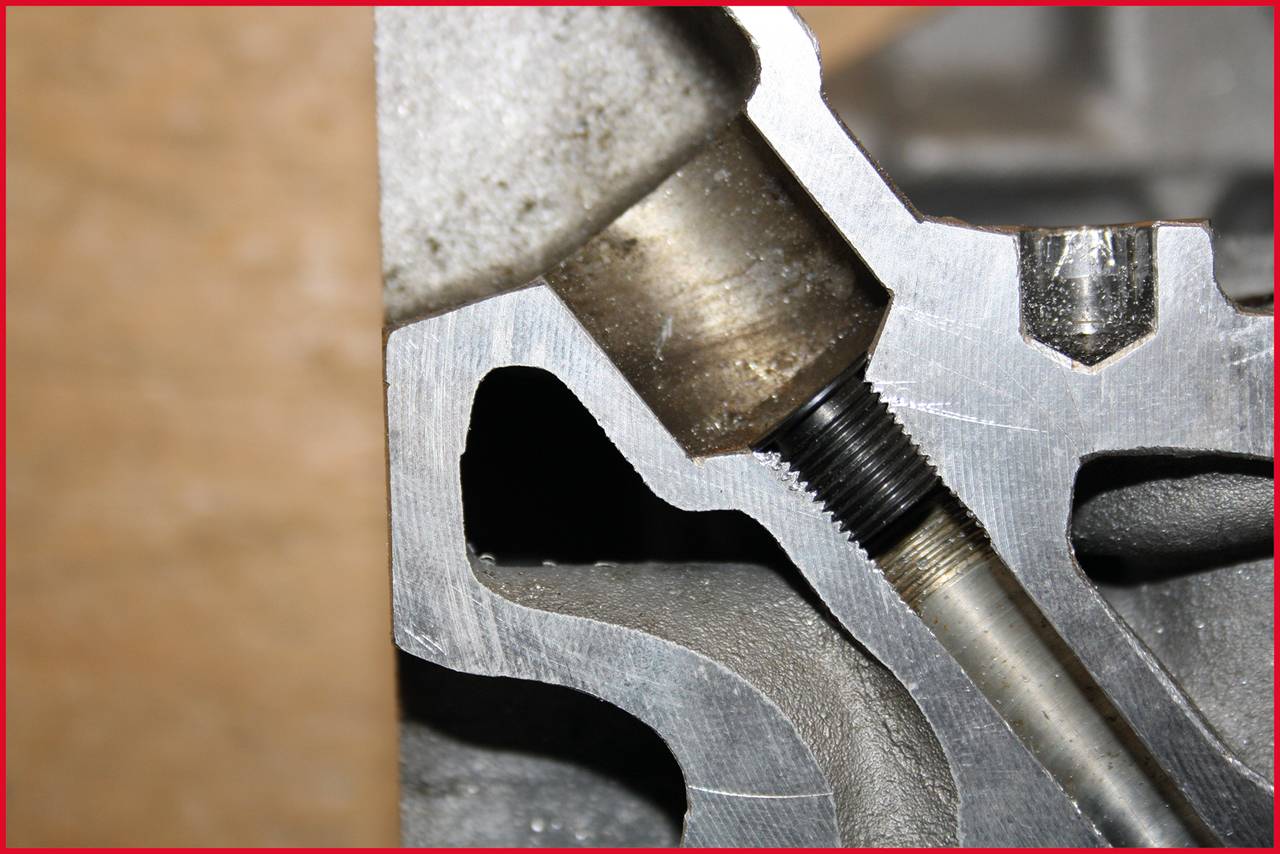 Nahaufnahme eines mechanischen Teils mit einem Gewindestift in einem Metallgehäuse; Detailansicht einer Maschine oder eines Werkzeugs.
