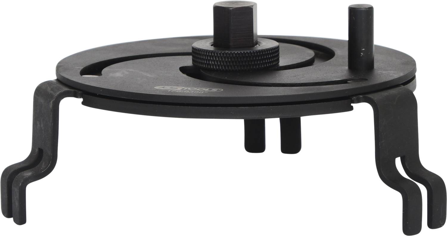 Schwarzes, kreisförmiges Metallwerkzeug mit zwei gebogenen Greifarmen und zentralem Einstellknopf. Hauptsächlich mechanische Funktionen.