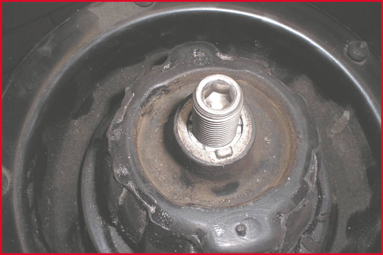 Konzentrierte Draufsicht auf eine zentrale Metall-Schraube in einem mechanischen Gerät, umgeben von einem kreisförmigen Gehäuse.