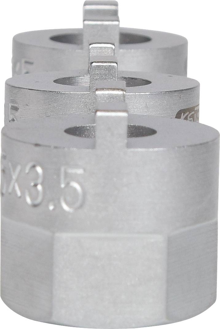 Drei metallische Zylinder in einer Reihe aufgestellt, mit eingravierten Zahlen und Buchstaben. Sie sehen aus wie mechanische Teile.