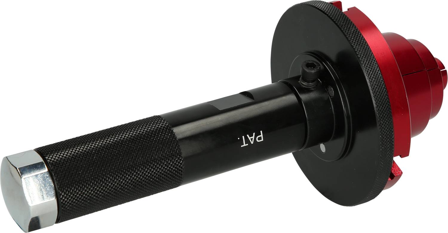 Ein schwarzes Werkzeug mit gerändeltem Griff und rotem Kopf. Auf dem Werkzeug steht 'PAT.'. Es scheint ein spezielles Handwerkzeug zu sein.