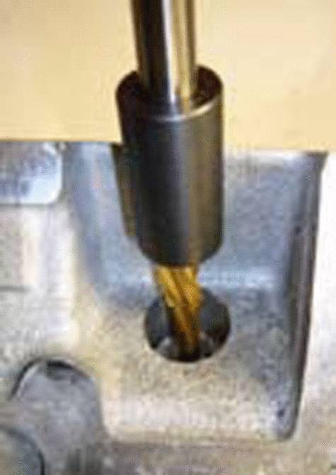 Ein Bohrer bearbeitet ein Metallstück, wobei ein zylindrisches Loch entsteht. Der Bohrer ist aus Messing und rotierender Bewegung dargestellt.