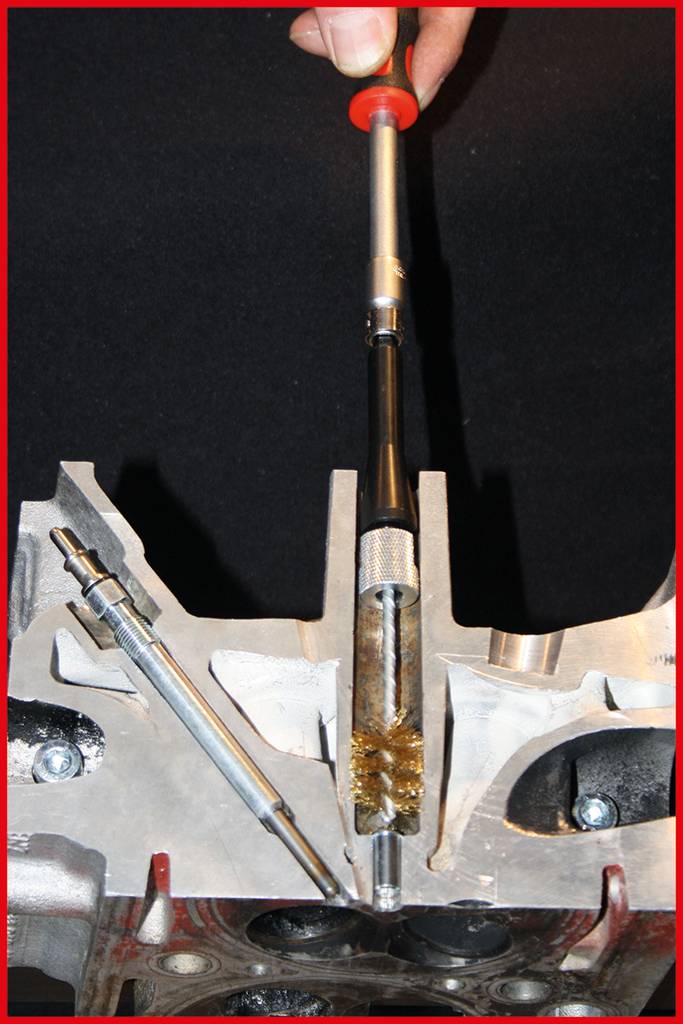 Ein Metallstab und ein Werkzeug werden in der Mitte einer metallischen Struktur gehalten, die wie ein Maschinenteil aussieht.