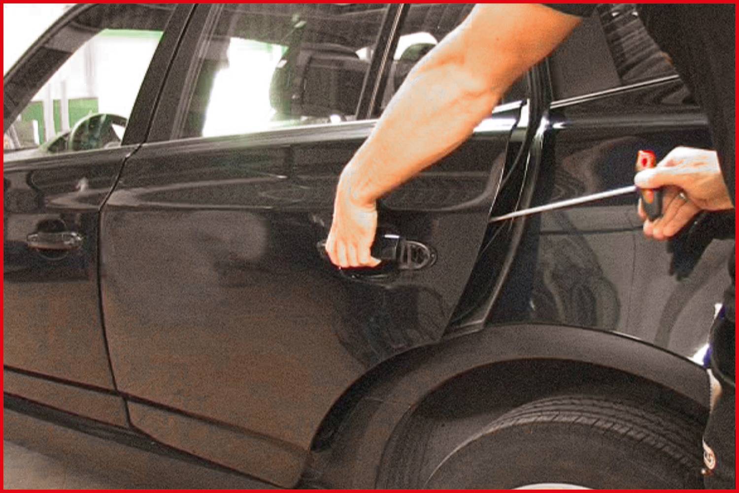 Eine Person versucht, mithilfe eines Schraubendrehers eine Autotür zu öffnen. Die Szene deutet auf einen möglichen Einbruch hin.