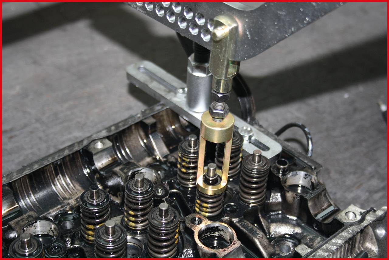 Eine Maschine bearbeitet Motorkomponenten, zeigt Ventilfedern und präzise Metallteile. Fokus auf industrieller Präzision und Technik.