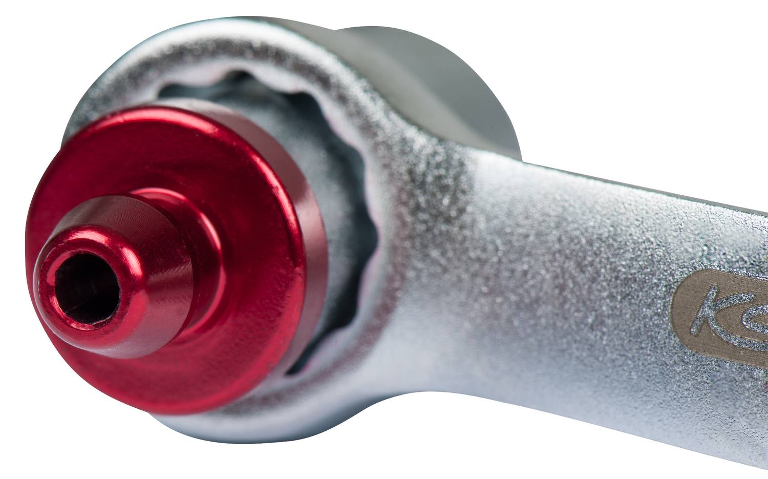 Silberner Schraubenschlüsselkopf mit roter Schraubverbindung in Nahaufnahme, geeignet für technische oder mechanische Anwendungen.