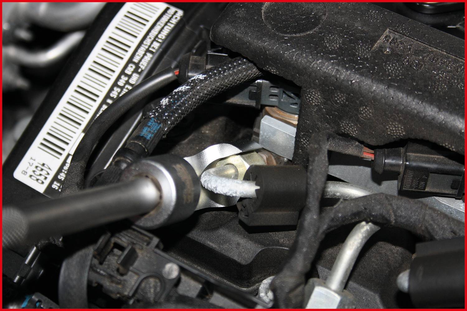 Ein Motor mit verschiedenen Kabeln und Anschlüssen. Ein Barcode-Etikett ist sichtbar. Hauptfokus auf Verkabelung und Motorstruktur.
