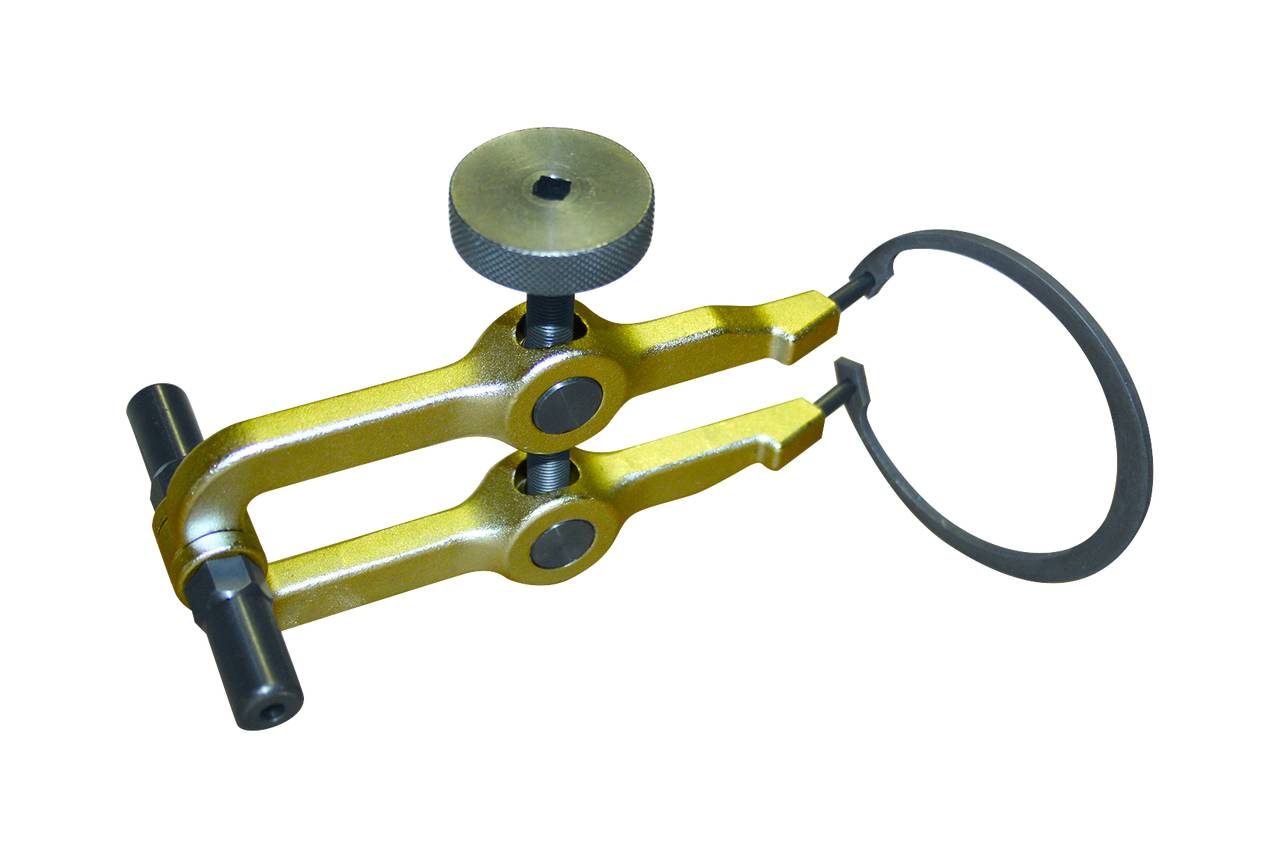 Ein gelbgoldenes Bremssattelanpassungswerkzeug mit einem schwarzen Metallring auf weißem Hintergrund.