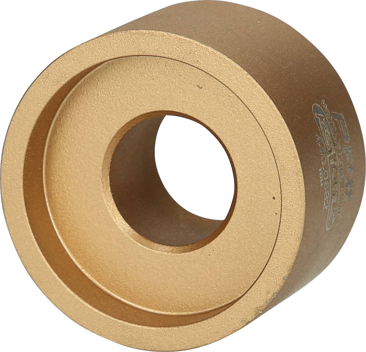 Goldenes, zylindrisches Metallteil mit einem zentralen Loch und einer eingefrästen Vertiefung auf der einen Seite.