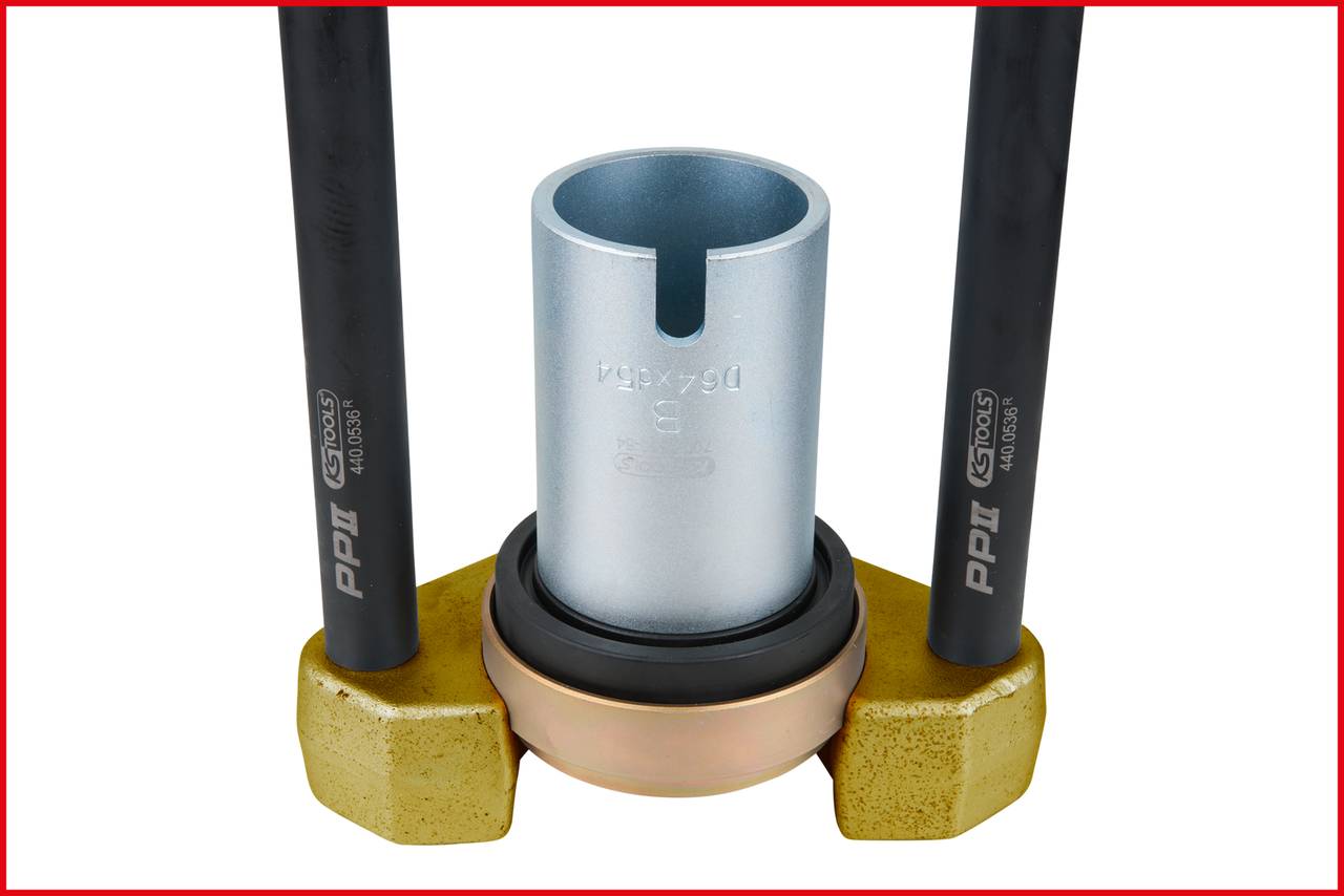 Zwei parallel angeordnete schwarze Rohre mit einer mittigen kreisförmigen Metallvorrichtung, umgeben von einer goldenen Basis.