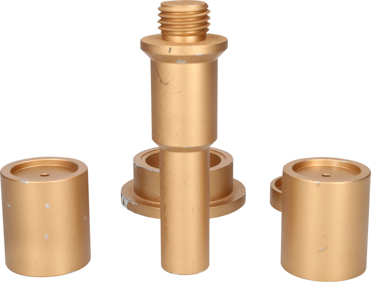 Goldene zylindrische Metallteile, bestehend aus einem längeren zentralen Stück mit Gewinde und zwei kürzeren zylindrischen Stücken.