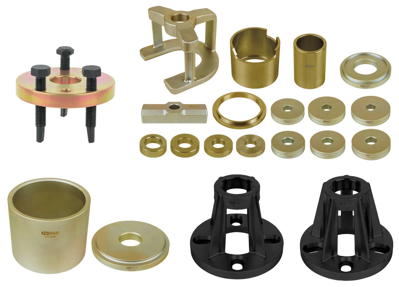 Ein Set verschiedener Werkzeuge und Adapter aus Metall, darunter Ringe, Buchsen und Halterungen, auf weißem Hintergrund angeordnet.