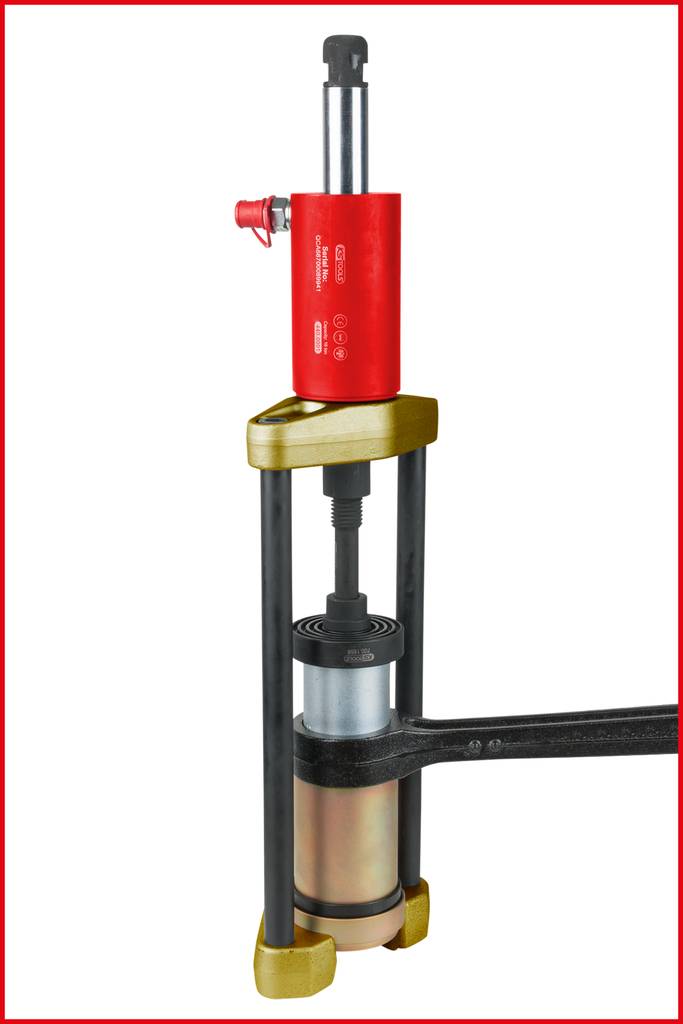 Eine rote hydraulische Presse mit Metallkappen und einem schwarzen Hebel zur Bearbeitung von Werkstücken. Sie ist robust und industrietauglich.
