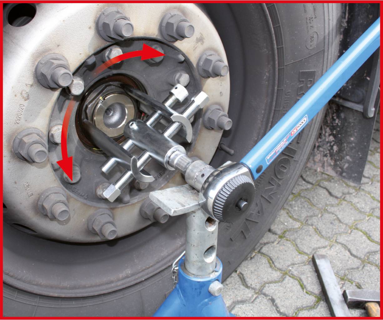 Ein Spezialwerkzeug wird verwendet, um mit einem Schraubenschlüssel die zentrale Mutter eines Lkw-Rads zu lösen.