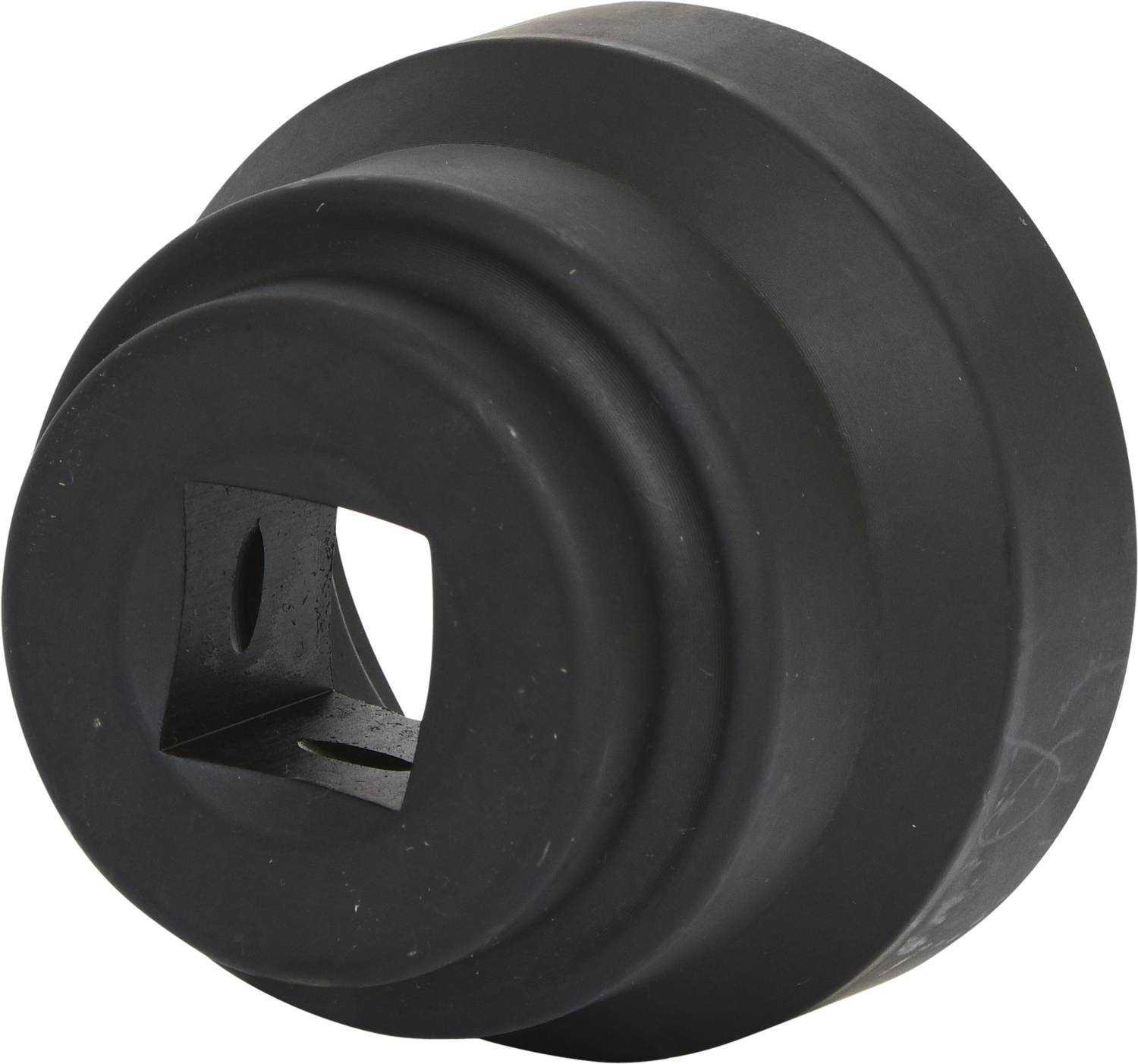 Ein schwarzes, rundes Gummibauteil mit einem quadratischen Loch in der Mitte und abgestuften Rändern.