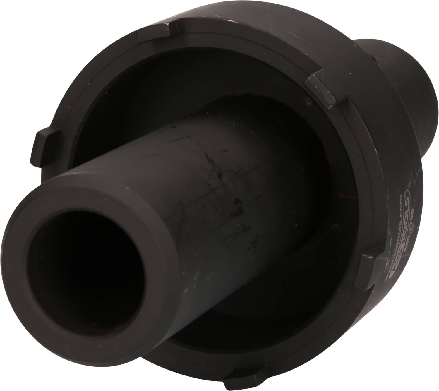 Ein schwarzes, zylindrisches Maschinenteil mit flanschähnlichem Rand, möglicherweise ein Adapter oder Verbinder aus Kunststoff.