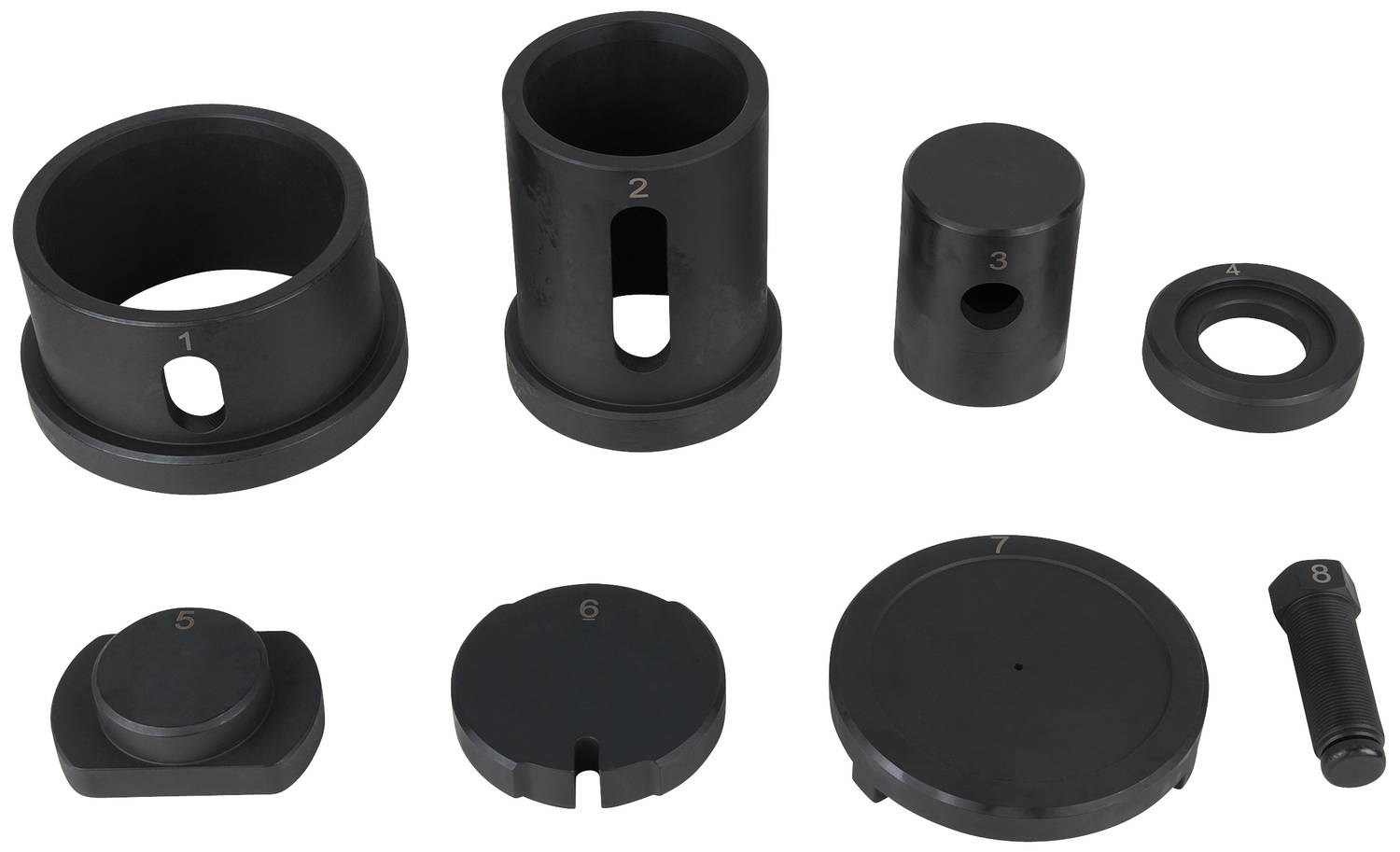Mehrere schwarze Metallteile liegen nebeneinander. Einige sind zylindrisch, andere flach oder scheibenförmig.