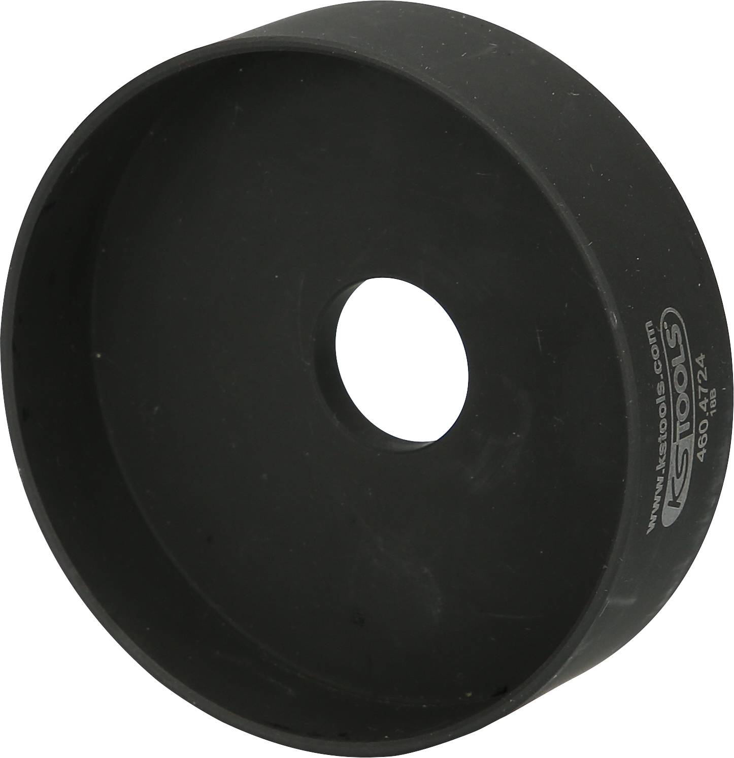 Rundes schwarzes Werkzeugteil mit mittlerer Öffnung, möglicherweise ein Adapter oder eine Kappe, mit Seriennummer an der Seite.