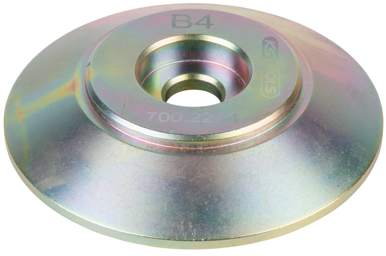 Flache Metallscheibe mit erhabener Mitte und Gravur 'B4' und '700.22.4'. Wahrscheinlich ein Maschinenteil oder eine Unterlegscheibe.