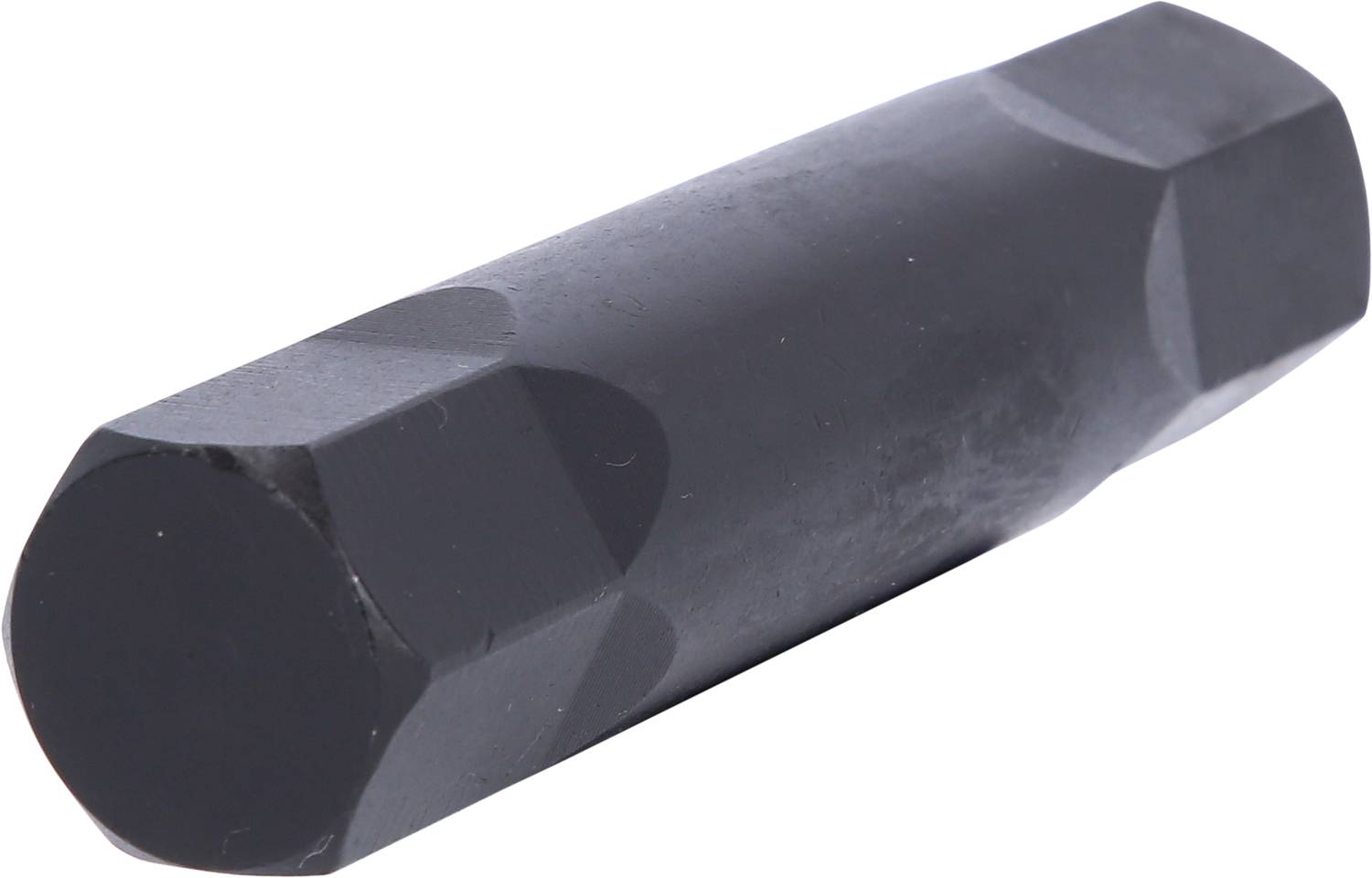 Ein schwarzes, sechseckiges Metallstück liegt horizontal. Es hat eine glatte Oberfläche und abgeschrägte Enden.