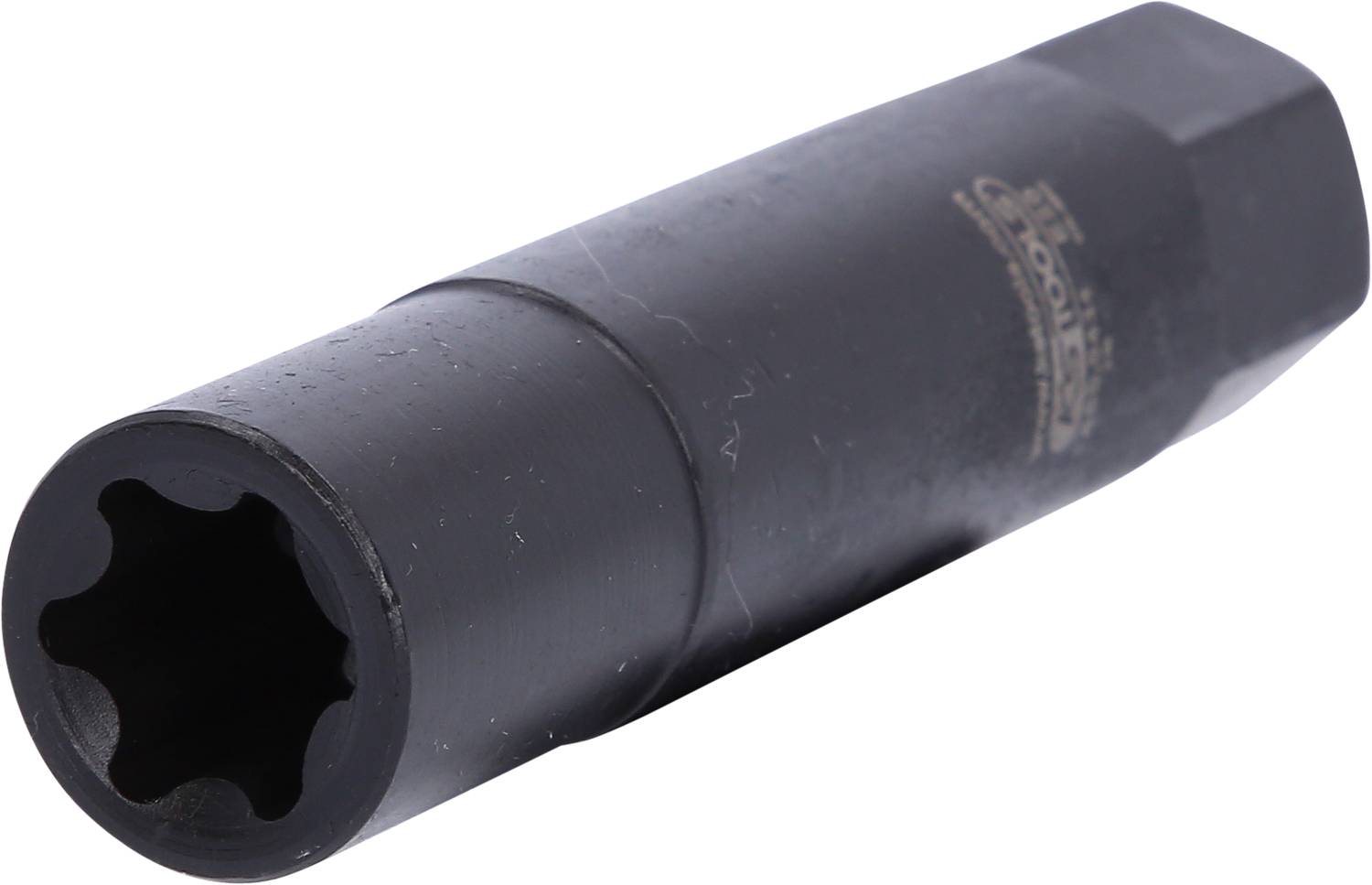 Schwarzer Schraubaufsatz mit sechszackiger Öffnung, vermutlich für spezielle Schrauben oder Muttern. Liegt schräg auf einer hellen Oberfläche.