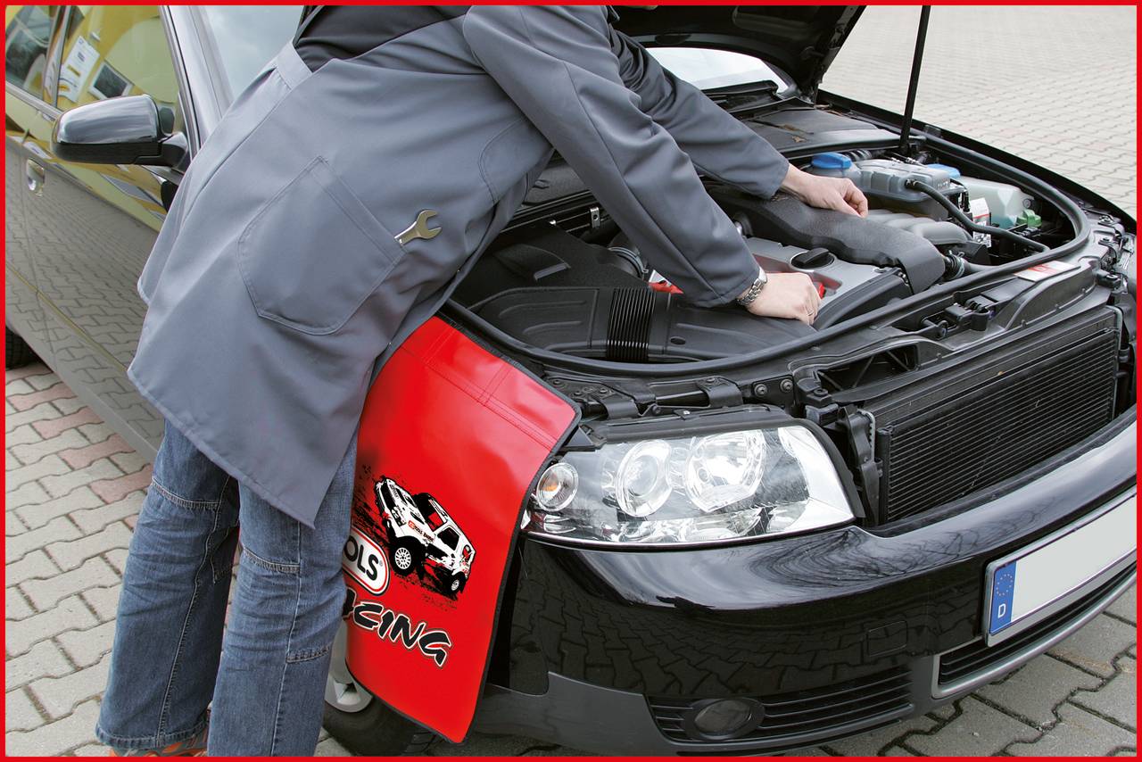Person repariert Auto, Motorhaube geöffnet, Fokus auf den Motorraum. Eine Schutzmatte mit Rennwagen-Motiv liegt auf dem Kotflügel.